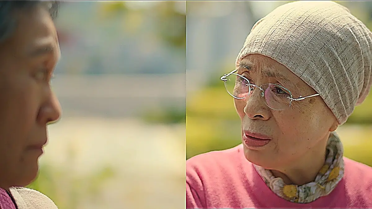 ベージュのニット帽と眼鏡を着用した女性が向かい合って話す様子