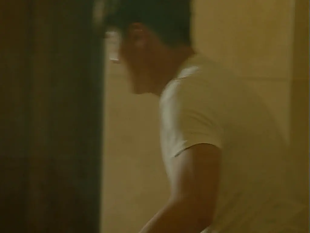 白い半袖Tシャツを着て横を向く男性の姿