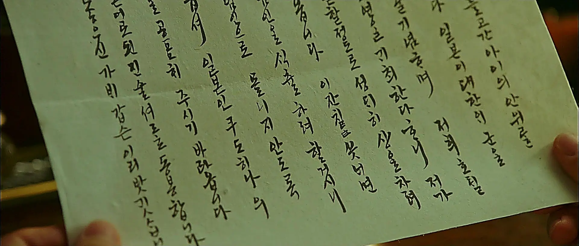 墨で文字が記された書状を手にする様子