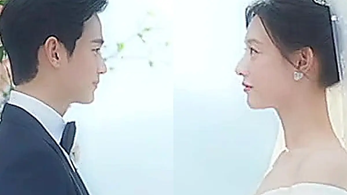 華やかな花のアーチの下で向かい合うペク・ヒョヌのタキシード姿とホン・ヘインのウェディングドレス