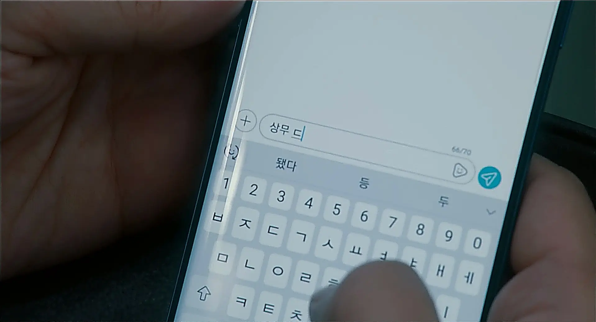 スマートフォンの画面で文字を入力している手元