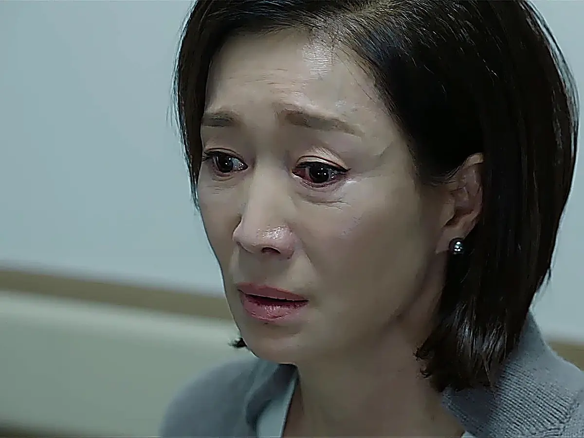 耳飾りの女性が正面を向いて目を潤ませている表情