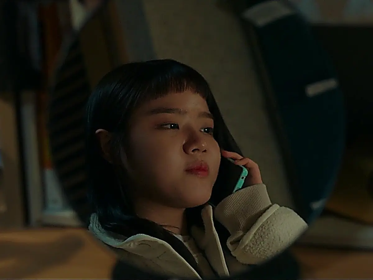 鏡の前でスマートフォンを耳にあてて神妙な顔つきで通話する女性