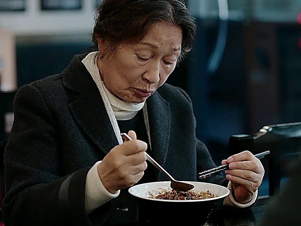 食堂のテーブルで向かい合い黙々とジャージャー麺を口にするオクドン