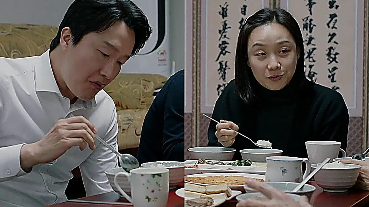 食卓でスプーンを持ち食事をとる白いシャツの男性と黒い服を着た女性